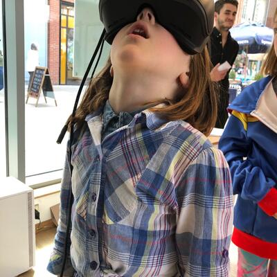 Young girl looking up as she uses a VR headset