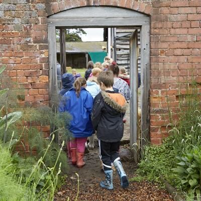 Young children walking through a garden door at an historic property