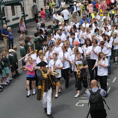 Parade through Hereford with young people playing instruments and schoolchildren watching