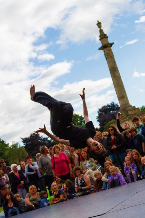 Dancer upside down in the air at an outdoor performance